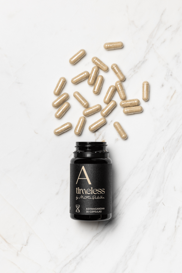 Frasco da ashwagandha deitada com cápsulas a sair do frasco